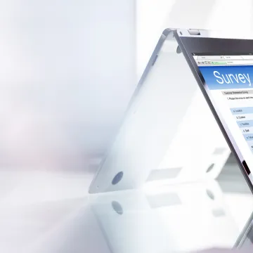 Eine Hand füllt eine Online-Umfrage auf einem Tablet-PC aus