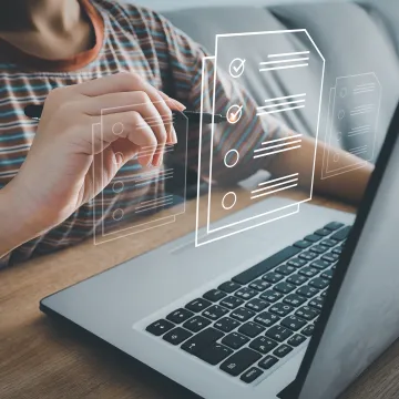 Person nutzt Laptop zur digitalen Umfrage oder Checkliste. Virtuelle Formulare mit Häkchen erscheinen über der Tastatur. Online-Befragung oder Aufgabenliste.