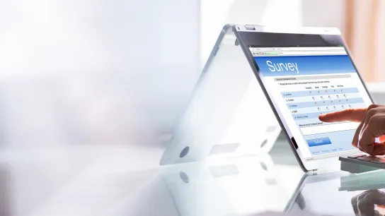 Eine Hand füllt eine Online-Umfrage auf einem Tablet-PC aus